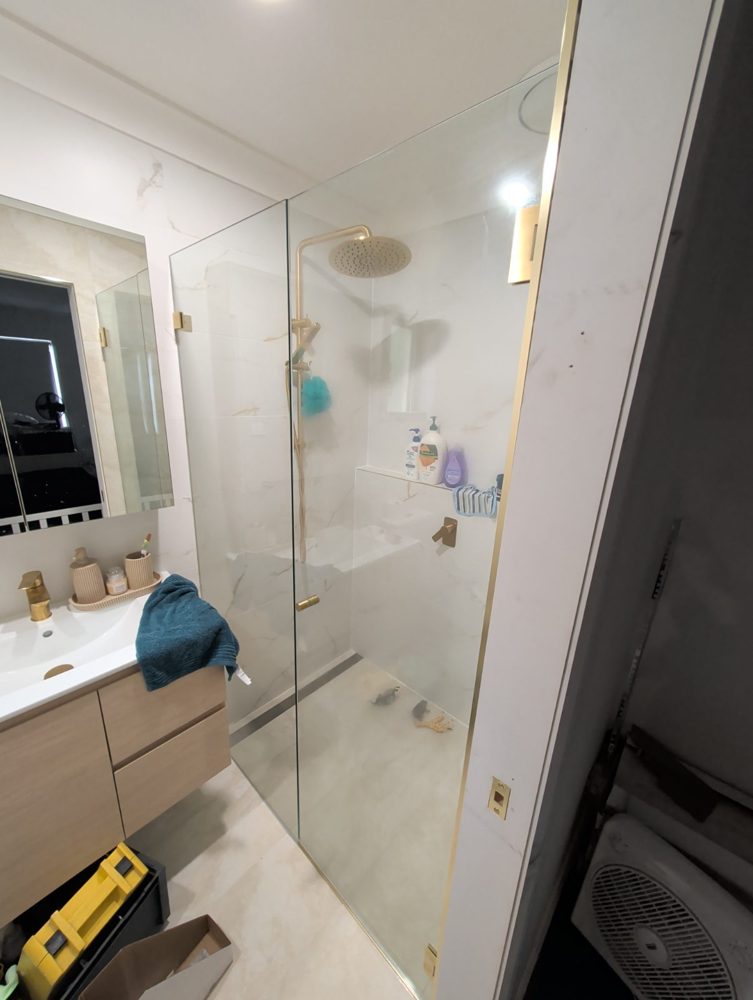 Frameless glass shower with brass fittings